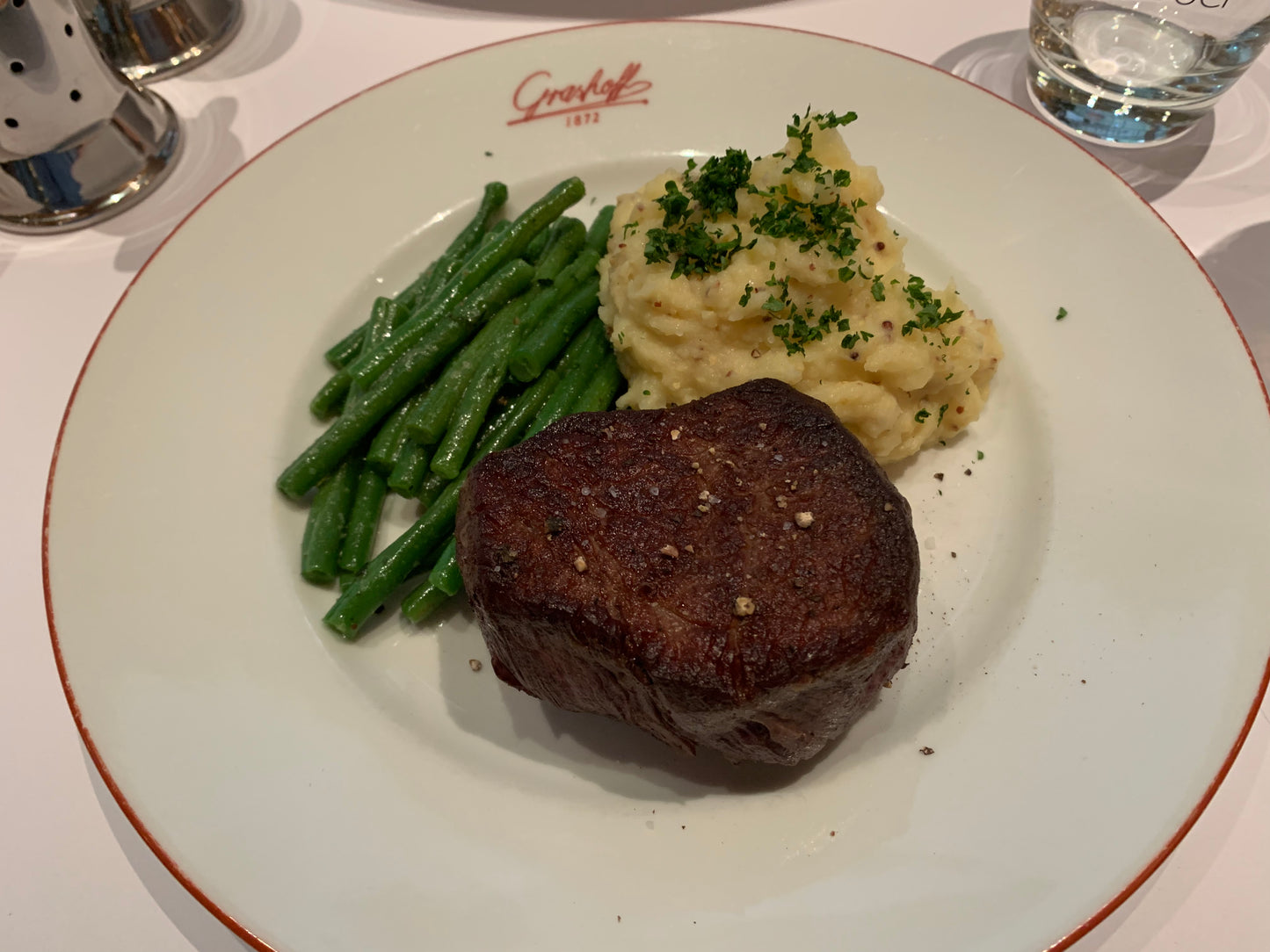 Teller mit Filetsteak, grünen Bohnen und Kartoffelstampf mit Moutart de Meaux, wartet auf die Hollandaise