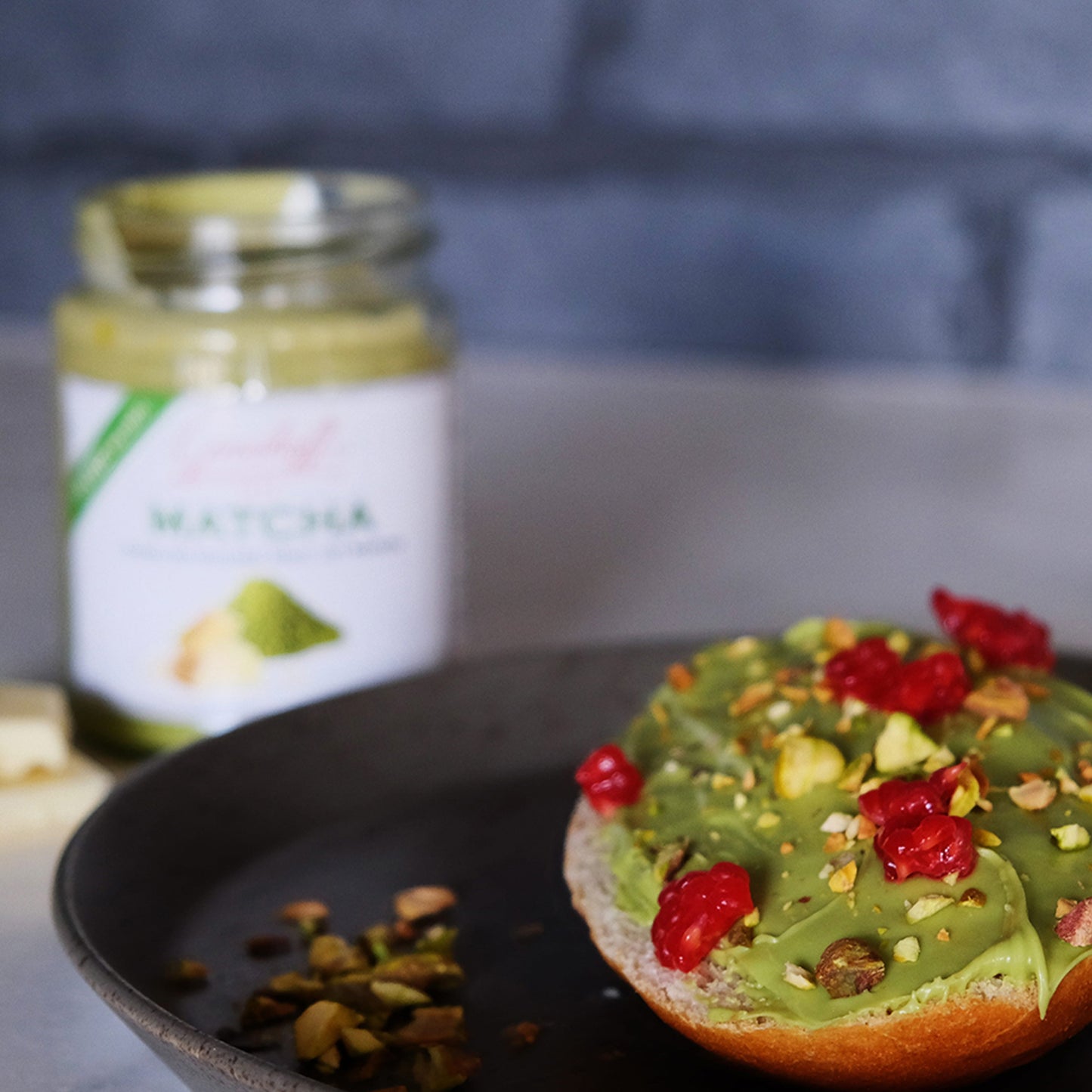 Ein Brioche mit Matcha-Schokoladencreme von Grashoff, bestreut mit Himbeeren und Pistazien.