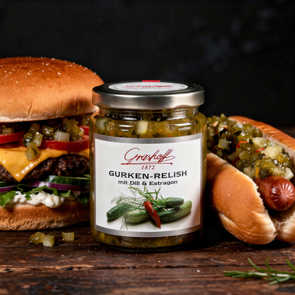 Ein Glas Gurken-Relish von Grashoff zwischen einem Burger und einem Hot Dog.