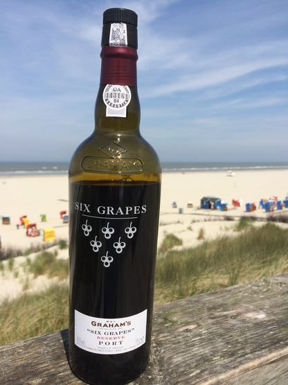 Eine Flasche Portwein auf Reisen am Strand von Juist
